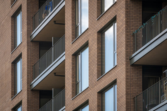 Modern Brick Apartment Building With Balconies Under Overcast Urban Sky in England UK