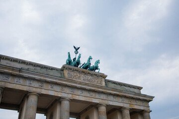 Top part of Brandenburg Gate or Brandenburger Tor monument biggest landmark in Berlin, Germany close up low angle view with grey moody sky background © elifilm