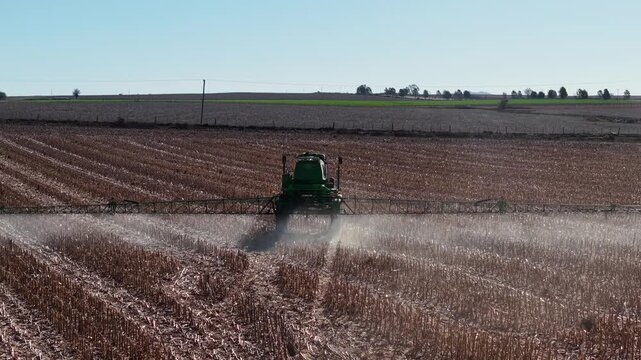 High angle 4K drone footage of farm machinery applying herbicides and fertilizers in Argentine pampas