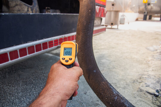Quality control: Measuring the temperature of the bitumen discharge hose with an infrared thermometer.