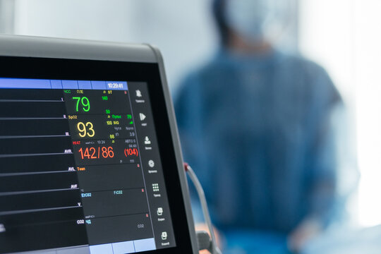 Close-up of a hospital vital signs monitor showing heart rate, blood oxygen saturation and blood pressure during perioperative patient care. Free copy space