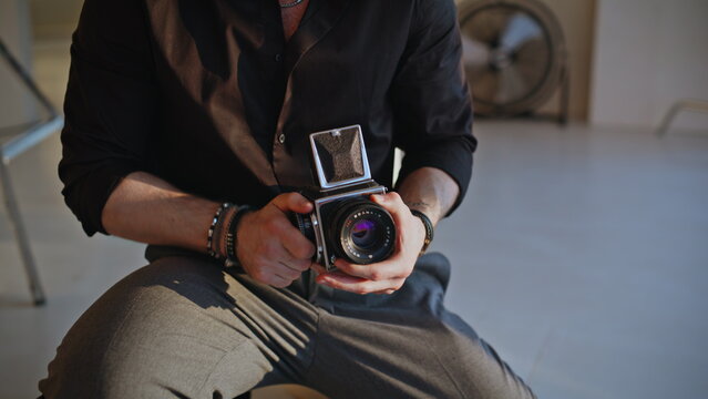 Vintage medium format camera male hands close up. Photographer talking studio.