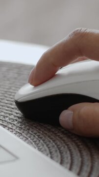 Hand using mouse next to laptop computer