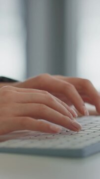 Hands typing on keyboard at desk
