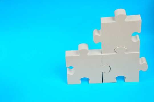 Interlocking puzzle pieces form a connected structure representing problem solving teamwork and strategic integration.
