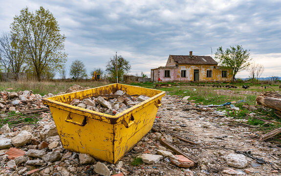 Yellow rubble container in rural Mura village landscape