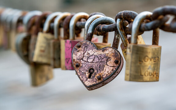Heart-shaped padlock on a line of locks on a chain