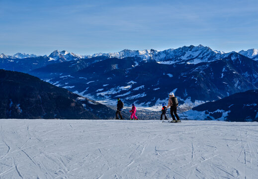 Family skiing above the valley at Zell am See in Austria