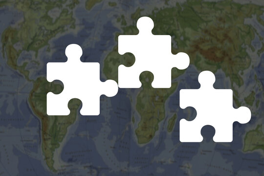 Puzzle pieces on a map of the world showing a connection and collaboration theme