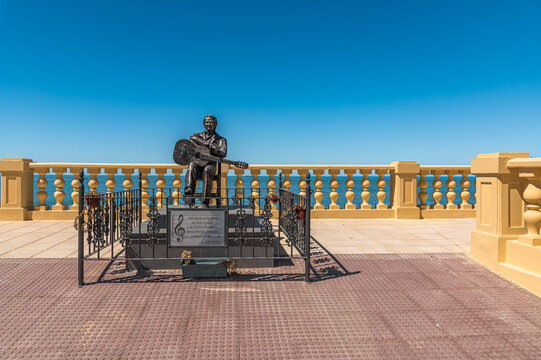 CHIPIONA, SPAIN - APRIL 5, 2023: Monument to flamenco guitarist Manolo Sanlucar in Chipiona, Spain, sculpture by Jose David Blanco Bernal depicts the musician seated with a flamenco guitar