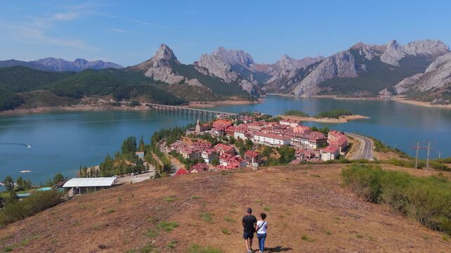 Summer rural tourism in the village of Ria&ntilde;o in Le&oacute;n, Spain. Tourist couple walking towards riano village in spain