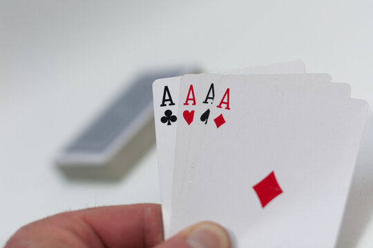 Poker Spielkarten Set mit Assen in der Hand auf weissem Hintergrund