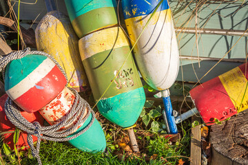 Commercial fishing industry and maritime heritage, weathered colorful buoys and nautical ropes stacked on a coastal dock for marine equipment © Endless Exploration
