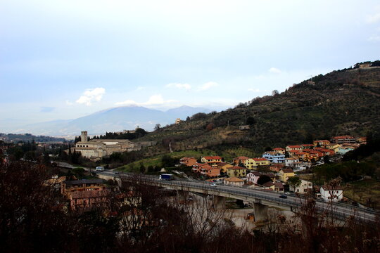 Panoramic landscape view from Spoleto, a valley crossed by a modern viaduct with the old town and hills in the background, and Monastero di San Ponziano, a romanesque-style, Former-Benedictine church
