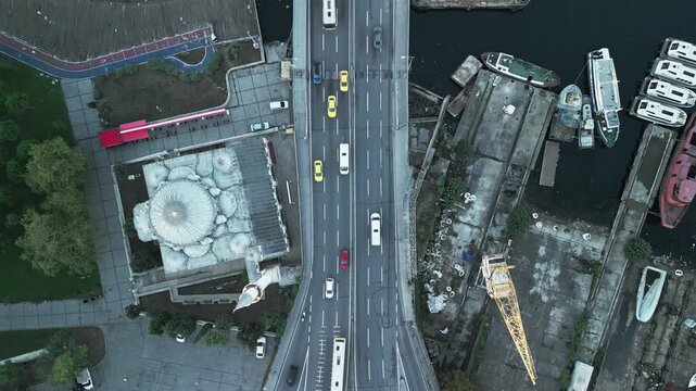 Turkey, Istanbul 06 10 2025: 4K top-down static drone video of Ataturk Bridge entrance with traffic, Sokullu Mehmet Pasha Mosque on left, and Halic Tersanesi Cesmesi on right.