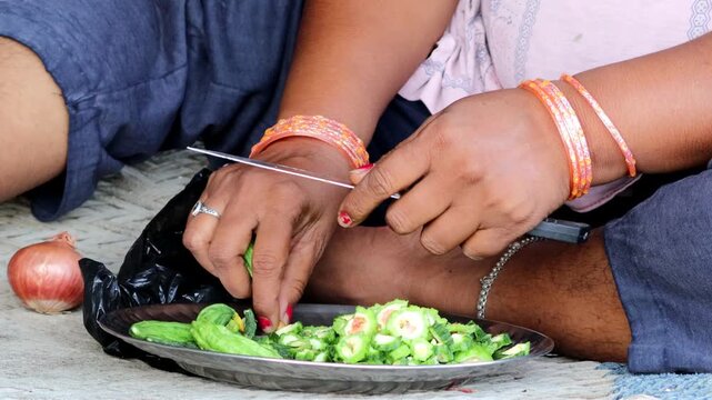 A woman chopping bitter gourd.
