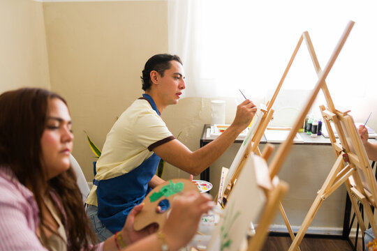 Students learning painting techniques in an art class, developing creativity and artistic skills on canvas easels