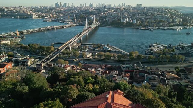Turkey, Istanbul 06 10 2025: 4K drone video moving forward over Eminonu bus station toward Golden Horn Metro Bridge, Ataturk Bridge, Galata, and skyscrapers in morning light.