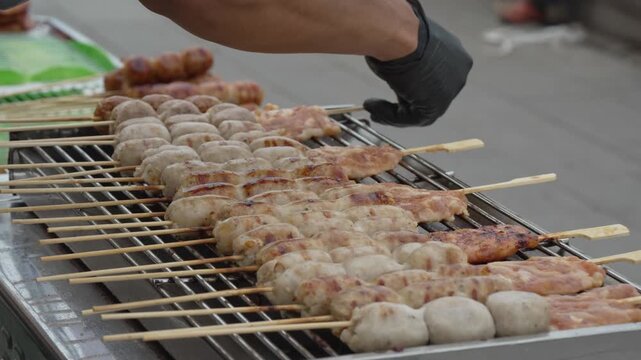 Street food skewers grilling over a charcoal barbecue