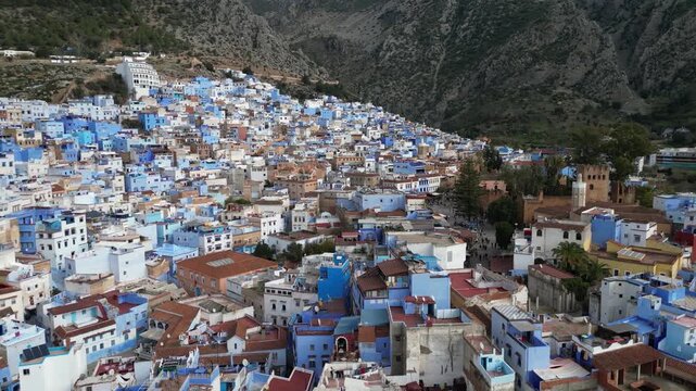 CHEFCHAOUEN, MOROCCO - DECEMBER 17,  2024: Wide aerial panoramic landscape view of the famous blue-painted medina buildings built on the slopes of the Rif Mountains.