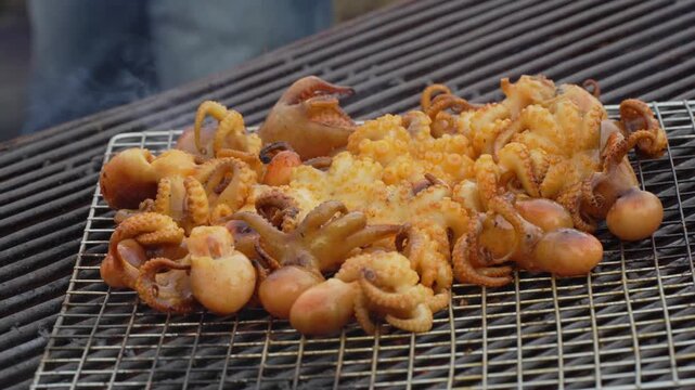 Fresh squid skewers grilling on a barbecue