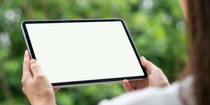 Woman holding tablet with blank screen outdoors