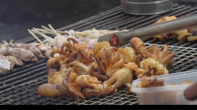 Golden grilled squid and seafood skewers on a barbecue