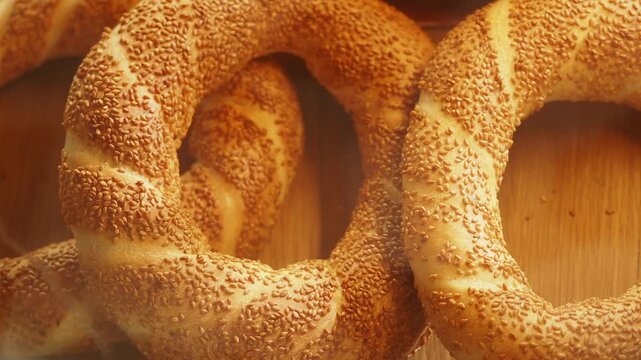 Freshly baked turkish simit bagels with sesame seeds on wooden surface, traditional pastry footage for breakfast and snack