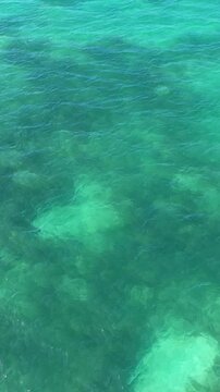 Aerial shot looking down at be beautiful blue ocean waters around the Florida Keys. Vertical video.