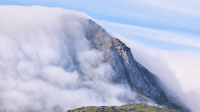 time lapse of the fog flowing over a mountain ialong the coast of Norway