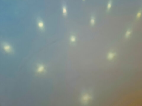 blurry background featuring soft out-of-focus yellow light spots against a smooth greyish-blue surface