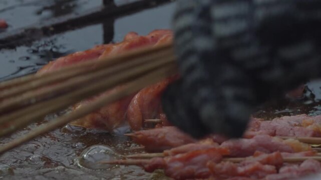 Fresh sausage skewers cooking on a hot street food grill