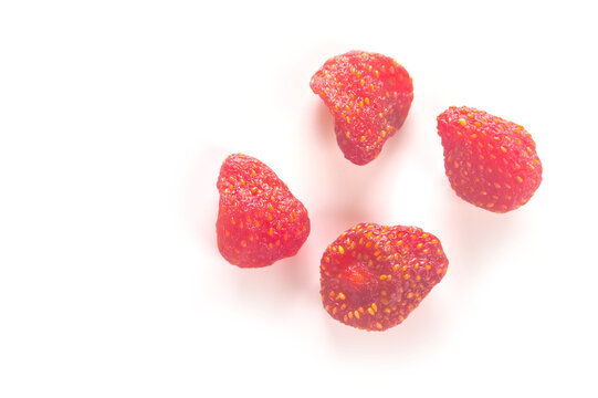 Four dried strawberries arranged on a white background