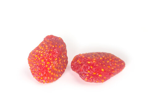 Two whole dried strawberries close up on white