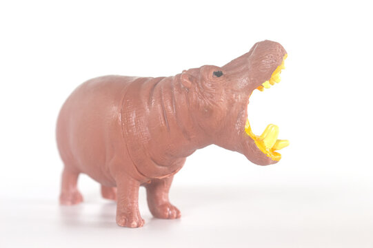 Realistic plastic hippopotamus toy figure with open mouth on white background