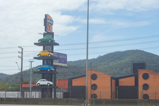 Balne&aacute;rio Cambori&uacute;, Brazil - September 18, 2026: Colorful vintage Volkswagen Beetle cars parked outside the Garage BC facade on an overcast day in Santa Catarina.