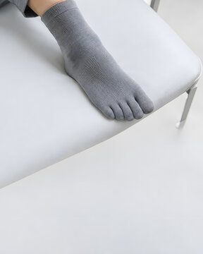 Foot wearing compression sock resting on exam table