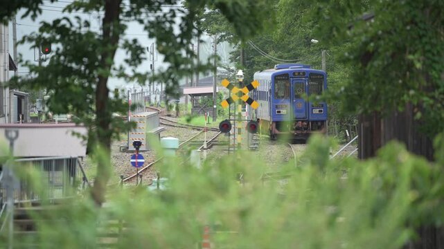 鳥取県若桜鉄道の踏切と青いローカル線の気動車が見える風景