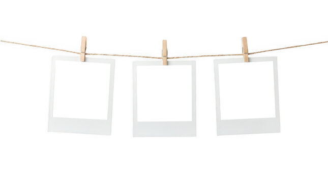 Three blank instant photo frames hanging on a clothesline isolated on transparent background