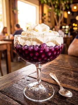 Blueberry Dessert with Whipped Cream in Glass on Wooden Table