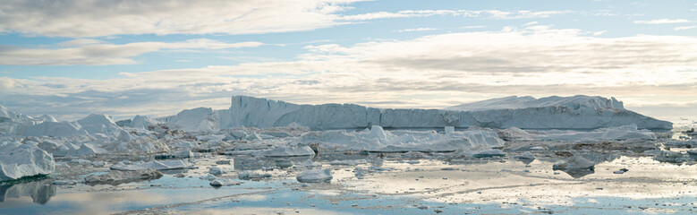 Global Warming and Climate Change - Icebergs and ice from melting glacier in icefjord in Ilulissat, Greenland. Panoramic banner © Maridav