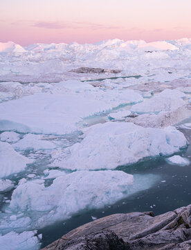 Iceberg from glacier in arctic nature landscape on Greenland. Aerial photo drone footage of icebergs in Ilulissat icefjord. Affected by climate change and global warming.