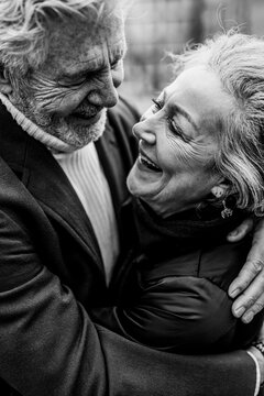 Joyful elderly couple embracing and smiling in black and white