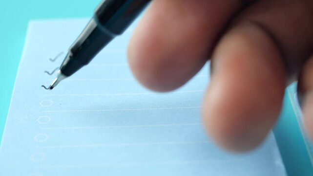 Close up hands checking off items on to do list with a pen, a person completing tasks, project management and productivity concept with animated check marks on blue paper