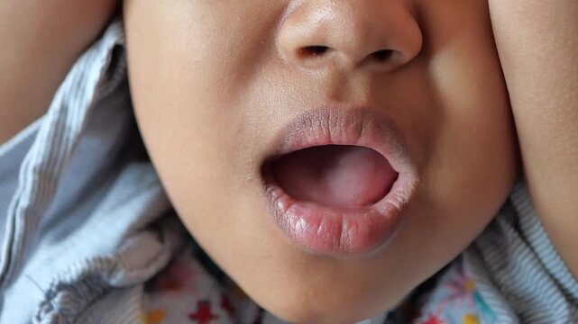 Close up shot of a young child&rsquo;s mouth open in surprise or shock
