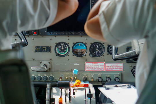Two pilots at the cockpit of a Cessna Grand Caravan 208B during a flight from Sabang Island to Banda Aceh, Indonesia. Two professional aviators sitting in cockpit during flight doing routine labors