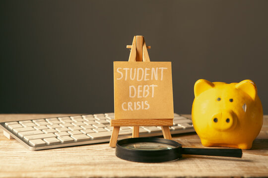 Piggy bank and sign with text STUDENT DEBT CRISIS