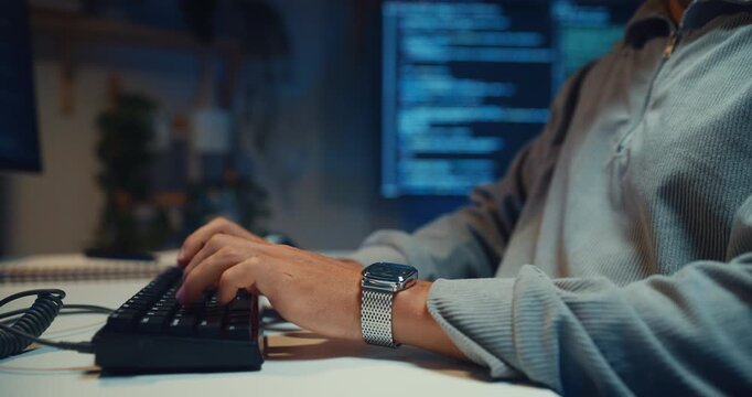 Closeup young adult male freelance developer typing write prompt AI bot app program nomad terminal coding at office night. Artificial intelligence dashboard, robotics user interface, machine learning.