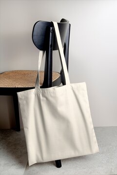 Minimal canvas tote bag hanging on modern chair