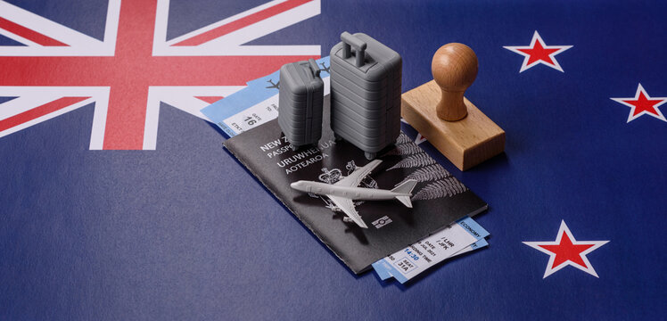 Two suitcases on a New Zealand flag representing the concept of travel, emigration